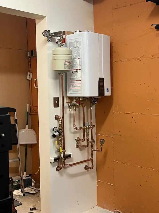Plumbing technician inspecting water heater connections in Richmond West